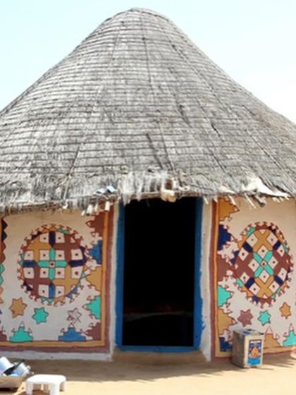 The source of our inspiration: a traditional Bhunga hut in Kutch, decorated with Lipan Kaam. The intricate circular motifs and embedded mirrors crafted by Rabari women are the direct influence for our Aabhla product line.