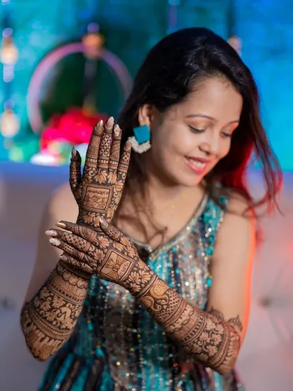 A beautiful shot of the bride displaying her full mehendi design. The focus is on the incredible artistry of the henna.