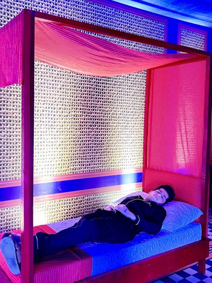 A bold, modern men's sleepover party featuring a red four-poster bed and custom checkerboard-patterned walls.