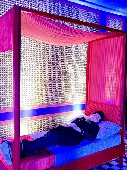 A bold, modern men's sleepover party featuring a red four-poster bed and custom checkerboard-patterned walls.