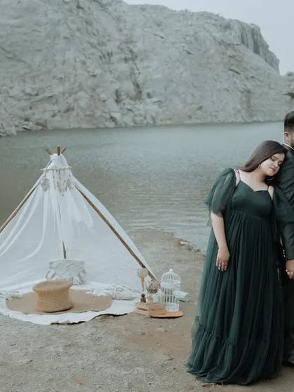 A wide shot of a couple standing by a lake, with a styled teepee in the background. This showcases our ability to create beautiful, themed pre-wedding shoots.