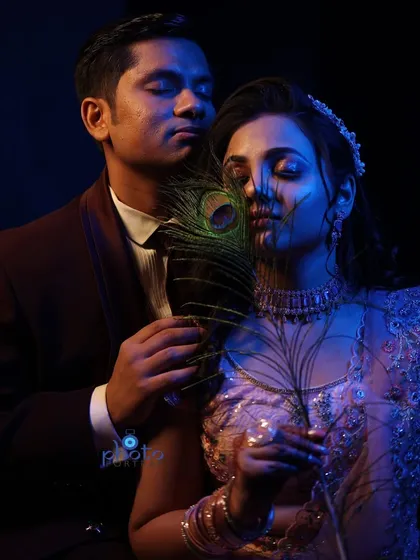 We also offer creative and artistic couple portraits. This moody, low-light shot uses a peacock feather and dramatic lighting to create a unique and intimate portrait that stands out.