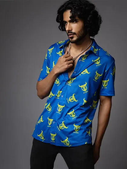 A three-quarter shot from the same menswear shoot, providing a better view of the shirt's fit and styling. The simple grey background ensures the product remains the center of attention.