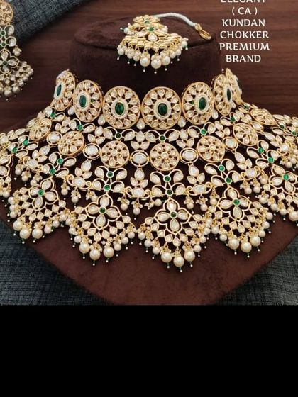 A premium, wide bridal choker with intricate floral Kundan work and pearl drops. This statement piece is available for rent and guarantees a grand look.