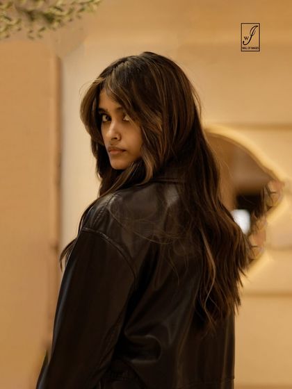 A striking over-the-shoulder portrait. The model's intense gaze and the soft focus of the background create a captivating and moody image.