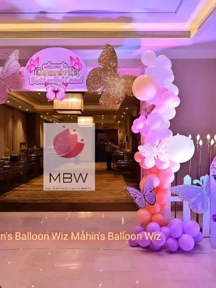 The grand entrance to the butterfly party, featuring a welcoming arch decorated with glittery butterfly props and a beautiful balloon arrangement.