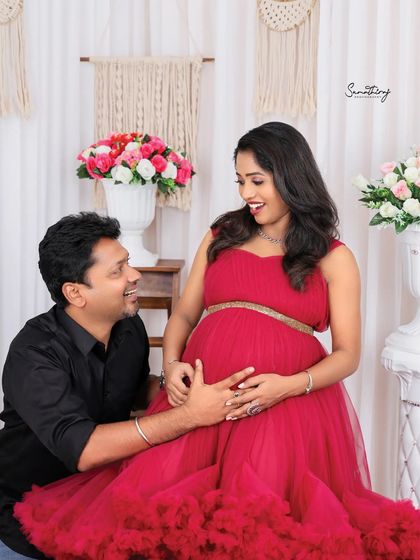 A joyful and candid moment between a couple in the studio. The wife's bright smile and the husband's loving gaze capture the happiness of their journey.