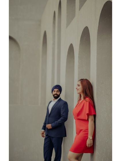 A modern and architectural pre-wedding portrait. The couple stands apart but connected, framed by the clean, minimalist arches of The Picture Villa.