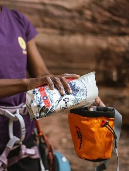 A climber gets her chalk bag ready for a sport climbing session. We make sure our participants have access to quality gear.