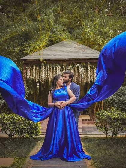A stunning shot of a flowing blue gown at the garden gazebo, creating a beautiful and dramatic effect.