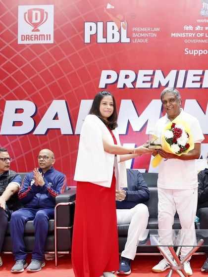 An organizer presenting a token of appreciation at the Premier Law Badminton League. The event was graced by several esteemed judges and ministers.