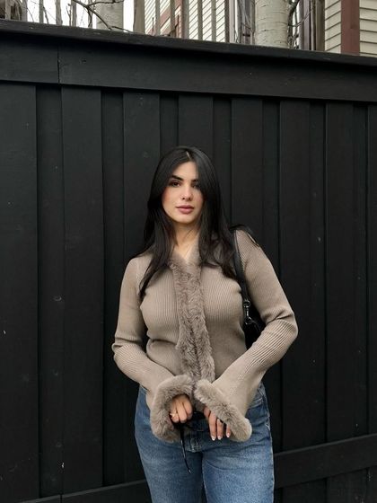 This is a classic OOTD shot for a SHEIN collaboration. The simple, clean background ensures the focus remains on the faux fur-trimmed cardigan and how it pairs with everyday denim.