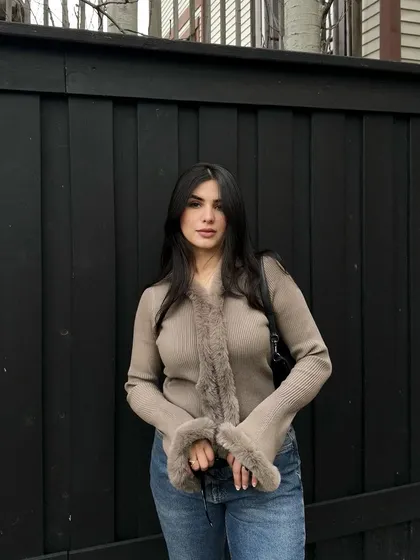 This is a classic OOTD shot for a SHEIN collaboration. The simple, clean background ensures the focus remains on the faux fur-trimmed cardigan and how it pairs with everyday denim.