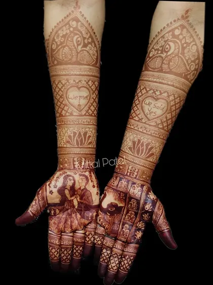The beautiful, dark stain of a custom engagement mehndi. This design features a couple portrait and the phrase "We Said Yes" in a heart, showing how the art develops.