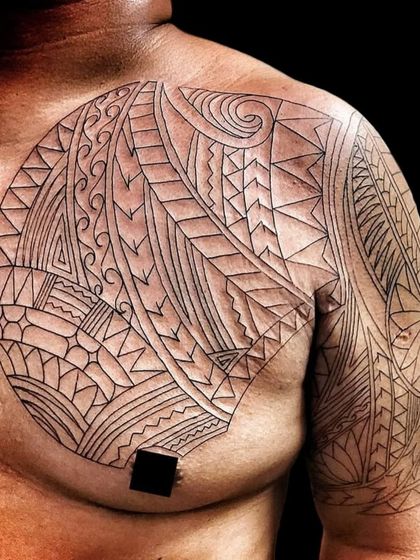 The beginning stages of a large Polynesian chest piece, showing the clean outline before shading. The foundation of a great tattoo is always a perfect stencil and clean line work.