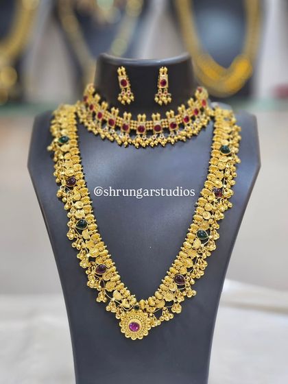 A traditional bridal set with a choker and long haar, featuring multi-colored stones for a vibrant look.