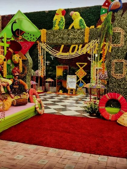 The main photo booth for a Teej party, showcasing a rich tapestry of colors and traditional Rajasthani decor elements, including puppets and kites.