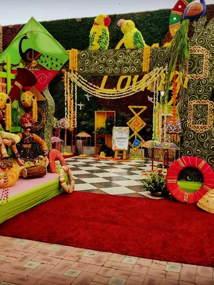 The main photo booth for a Teej party, showcasing a rich tapestry of colors and traditional Rajasthani decor elements, including puppets and kites.