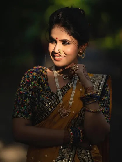 A beautifully lit portrait that highlights the model's features and the rich texture of the saree. The soft, natural makeup ensures she looks effortlessly radiant.