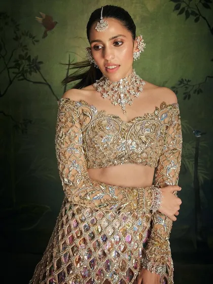 This gold Manish Malhotra lehenga is the definition of glamour. The off-shoulder blouse and intricate, cage-like overlay on the skirt create a look that is absolutely fire for a reception or cocktail night.