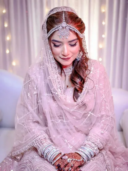 A close-up of her serene expression. The makeup is soft, with a focus on flawless skin and shimmery eyes.
