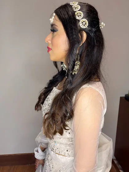 A side profile of Yutika's wedding guest look. You can see the details of the hair accessories and the beautiful, curled hairstyle.