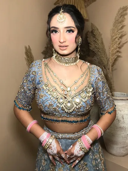 The full bridal look, with the powder blue lehenga and heavy kundan jewelry, is a perfect example of modern bridal styling.