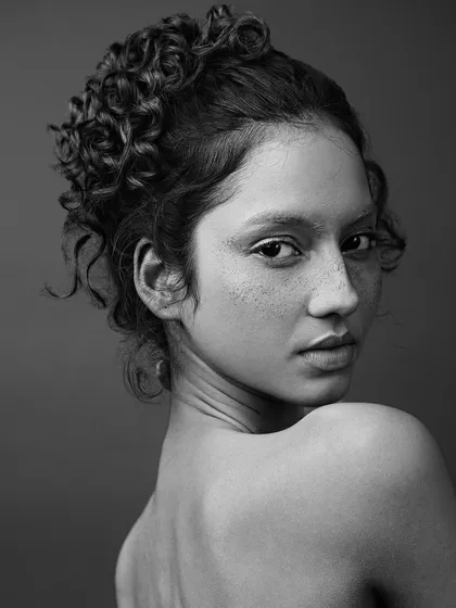 The same look in black and white, which strips away the color and puts the focus entirely on the form, texture, and the model's intense expression.