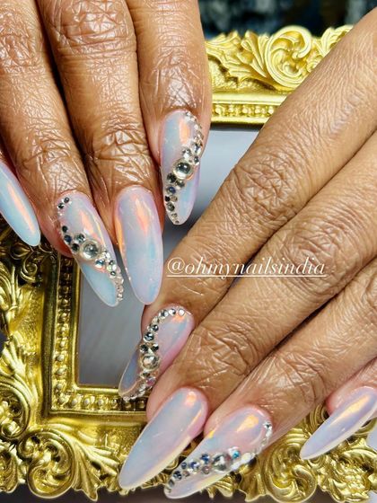 Client-favorite chrome nails with a touch of bling. This design features an iridescent chrome base with accent nails covered in sparkling silver crystals.