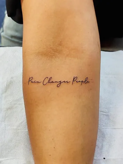The quote "Pain Changes People" in a delicate, fine-line script. A powerful and personal motto to carry with you.