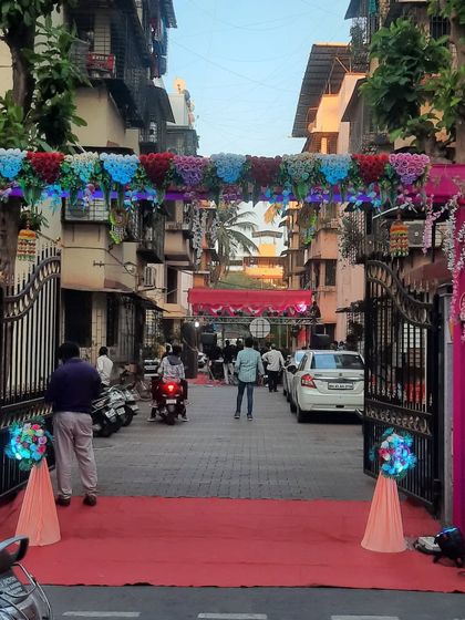The same entrance gate during the day, showing the vibrant colors of the flowers and drapes.