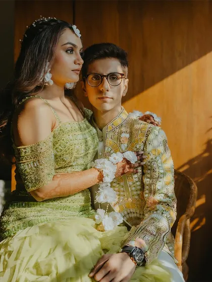 A sun-kissed, artistic portrait of a couple during their Haldi celebration, showcasing their modern and stylish outfits.
