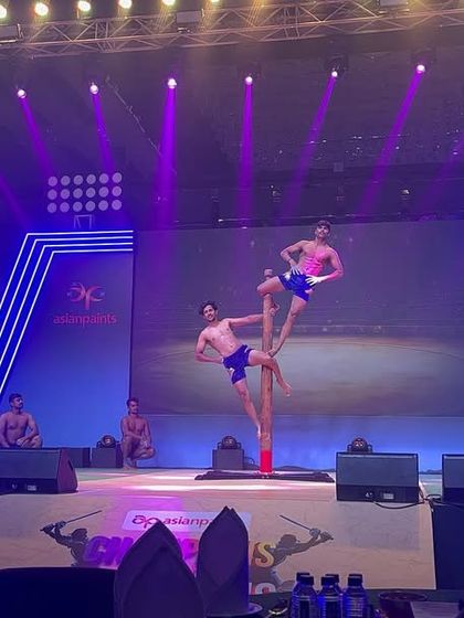 Another dynamic shot from our stage performance in Ahmedabad. The combination of athletic poses and dramatic lighting created a memorable spectacle for the audience.