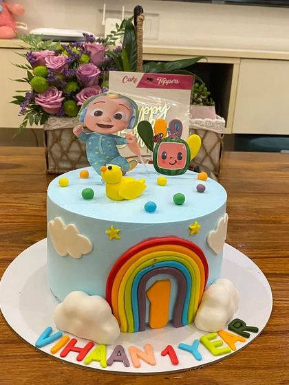 A clean and cute Cocomelon cake for a first birthday. The simple design with a rainbow and fondant characters makes for a sweet and memorable celebration.