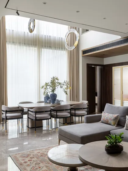 This family room combines a comfortable chaise lounge with an elegant dining area under a double-height ceiling. The design ensures that everyday family life is conducted in a setting of effortless style.