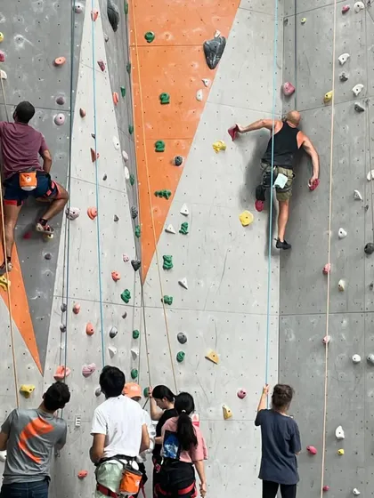 Two climbers tackle challenging overhangs, showcasing the strength and technique required for advanced routes.