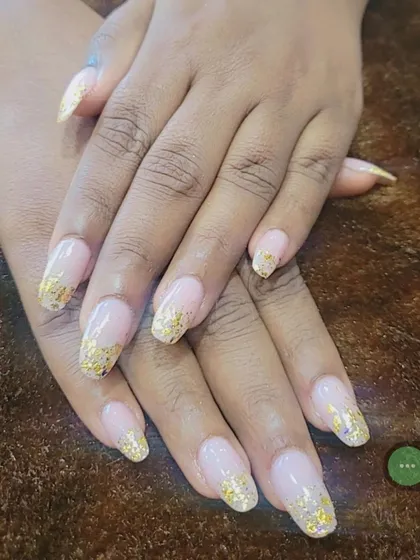 I love how these gold foil flakes look scattered over a natural nude base. This set features long, coffin-shaped nails, giving a modern and luxurious feel that I can create for you right at your home.