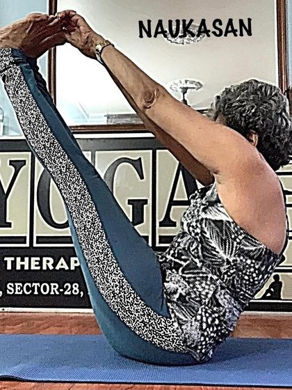 A clear side view of Naukasan (boat pose), showing the 'V' shape that engages the abdominal muscles.