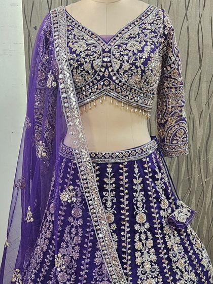 A beautiful deep purple lehenga with heavy silver and mirror work embroidery. This rich color is a fantastic choice for a sangeet or reception night.