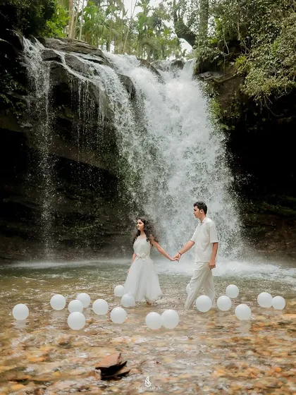 A dramatic and adventurous pre-wedding shoot at a secluded waterfall near Coorg. For couples who want something truly unique, we can incorporate creative elements like these floating balloons to make the scene unforgettable.