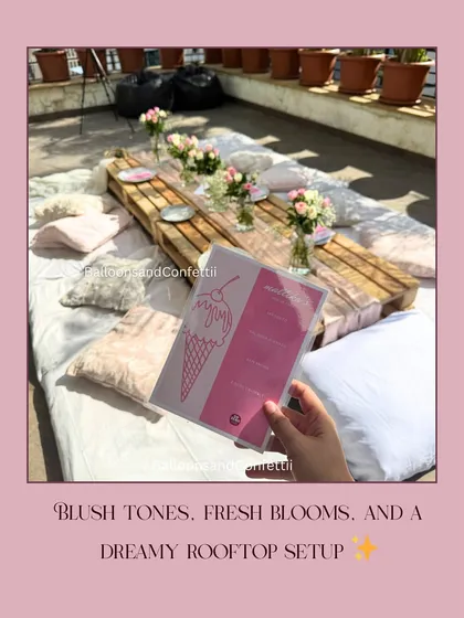 Blush tones, fresh blooms, and a dreamy rooftop setup. This image highlights the custom menu card designed to match the picnic's aesthetic.