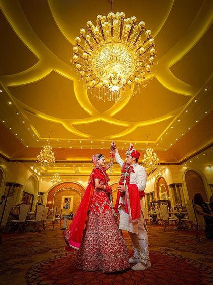 A grand, wide-angle shot of the couple dancing under a massive chandelier. I use angles like this to make the scene feel epic and luxurious.