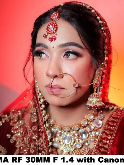 A bridal portrait shot with the Sigma 30mm f/1.4 lens on a Canon R50, showing excellent sharpness and color against a red-lit background.