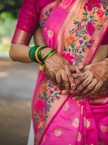 A detail shot focusing on the couple's embrace and the bride's beautiful pink saree. This highlights both the connection and the stunning wedding attire.