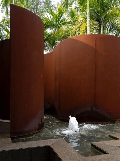 A close-up of the fountains and curving Corten steel walls at KEUS. The movement of the water adds life and sound to the installation, contrasting with the solid, rusted steel.
