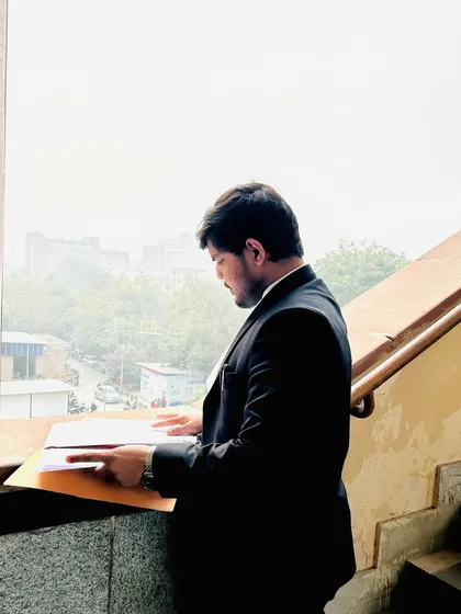 Reviewing a file by a window. I don't wait for opportunities to happen; I create them through meticulous preparation and strategic action.