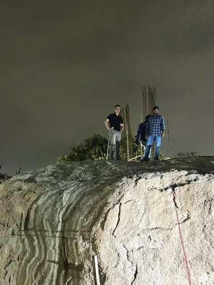 Our team atop the main boulder that anchors the Lurra House. The project is designed around this distinctive natural feature, making the rock an integral part of the home's identity.