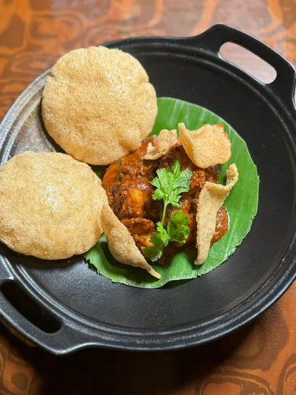 Goan Prawn Balchao served with fluffy Poi bread. This dish packs a punch with its spicy and tangy marinade, offering guests a bold taste of coastal Indian cuisine.
