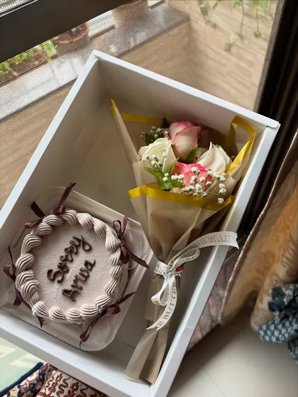 Sometimes, a sweet gesture is the best way to say you're sorry. This hamper includes a custom bento cake with the message "Sorry Arwa" and a beautiful bouquet of fresh roses, all packed in a simple white gift box.