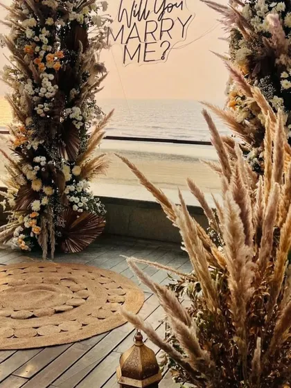 This detail shot highlights the texture of the pampas grass and dried floral elements used in the proposal arch. The combination of different natural elements gives the boho decor an authentic and earthy feel.